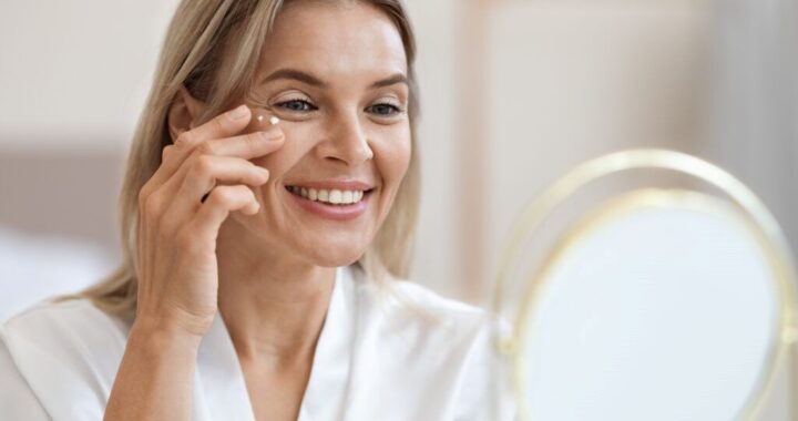 Woman applying anti-aging skincare cream as part of an affordable daily skincare routine