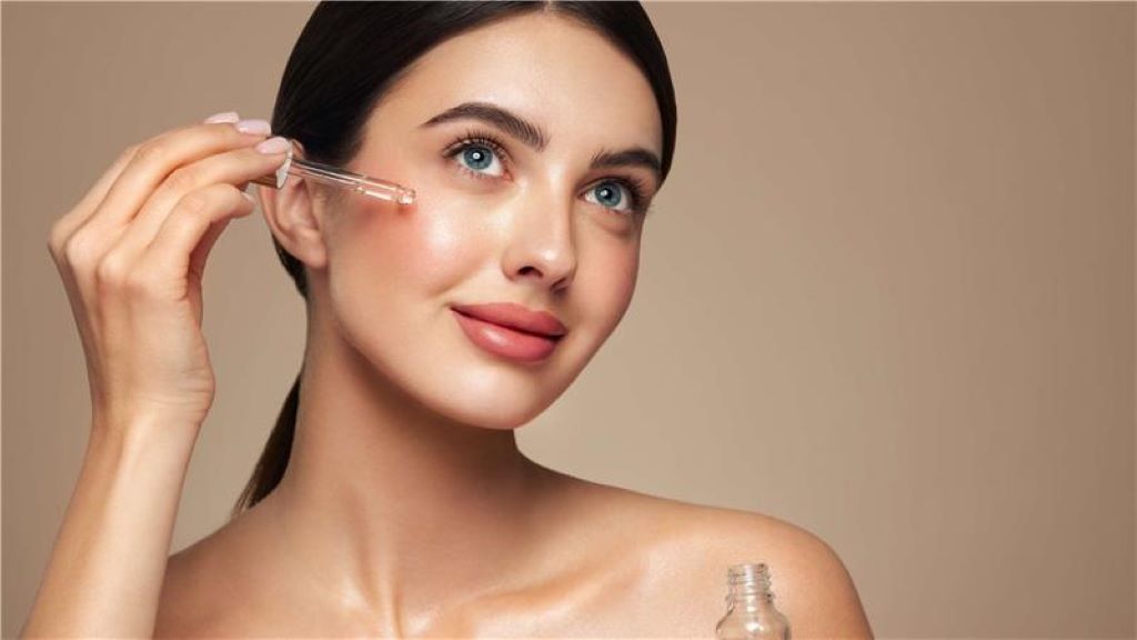 Woman applying glow-boosting serum for brighter and radiant skin care results