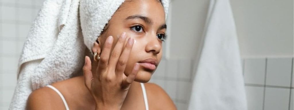 Woman applying Vitamin C serum to hydrate and brighten facial skin